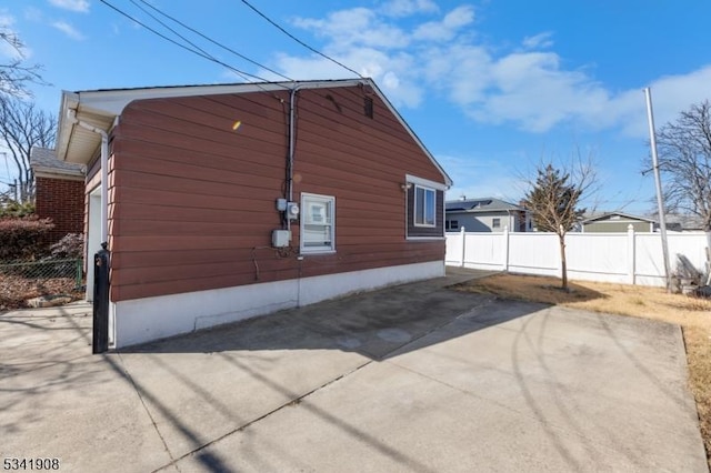 view of property exterior featuring fence and driveway