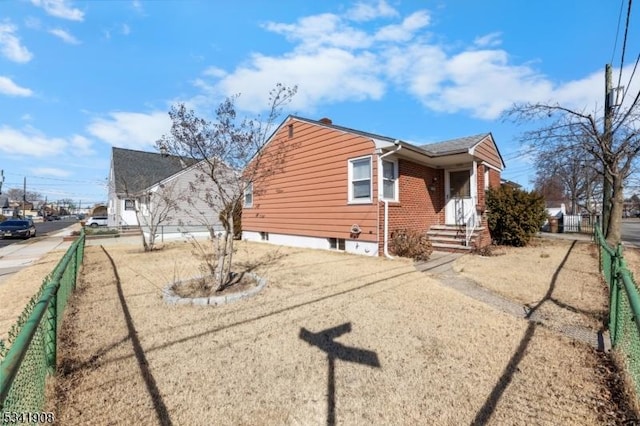 view of side of property with brick siding and fence