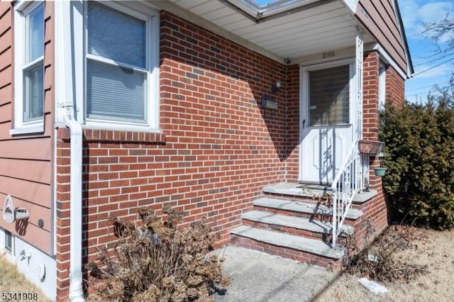 doorway to property with brick siding