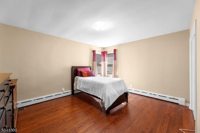 bedroom with baseboard heating and wood finished floors