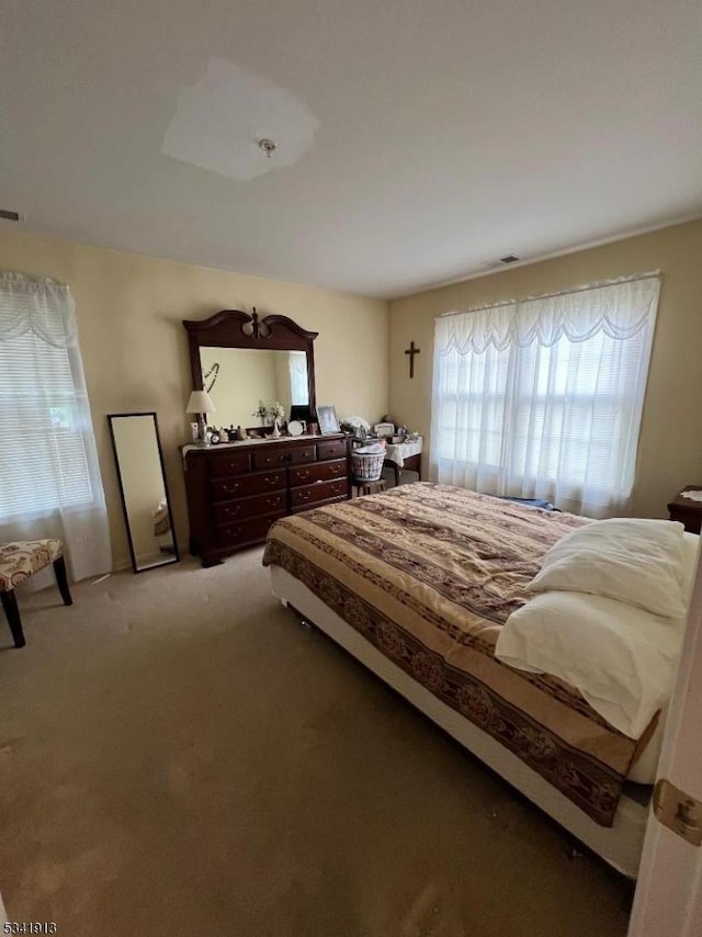 bedroom with light colored carpet and visible vents