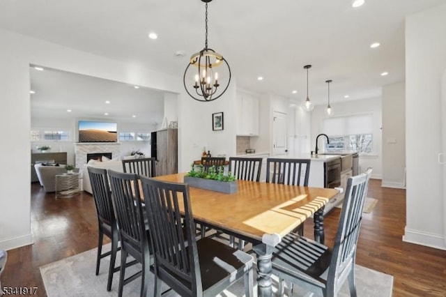 dining area with recessed lighting, dark wood-style flooring, a fireplace, and baseboards