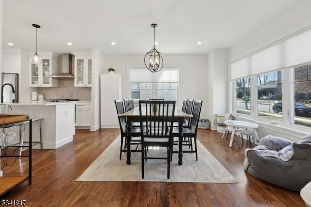 dining room with recessed lighting, dark wood finished floors, and a notable chandelier