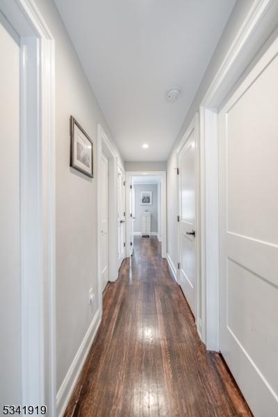 hall featuring dark wood-style floors and baseboards