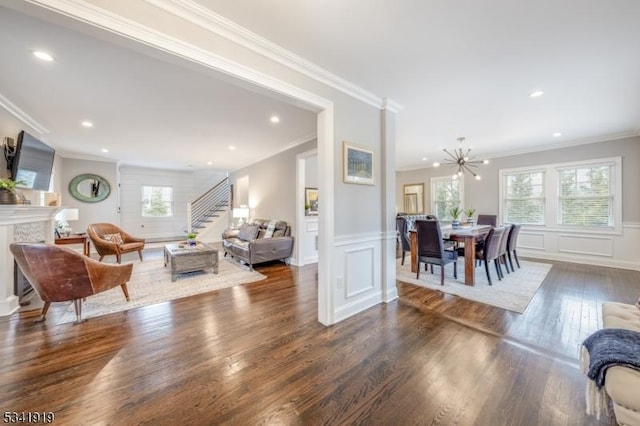 living room with a premium fireplace, wood finished floors, a wealth of natural light, and a decorative wall