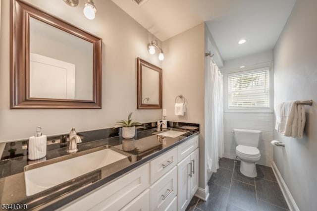 full bath featuring tile patterned flooring, a sink, toilet, and double vanity