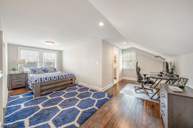 bedroom featuring lofted ceiling, multiple windows, baseboards, and hardwood / wood-style flooring