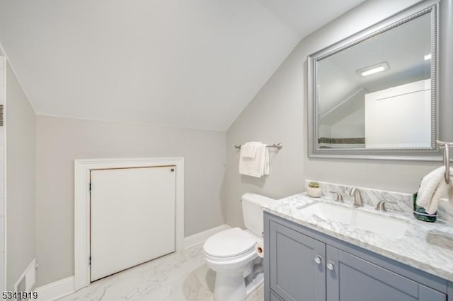 bathroom with toilet, vanity, baseboards, vaulted ceiling, and marble finish floor