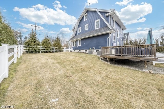 exterior space featuring a gambrel roof, a fenced backyard, a lawn, and a wooden deck