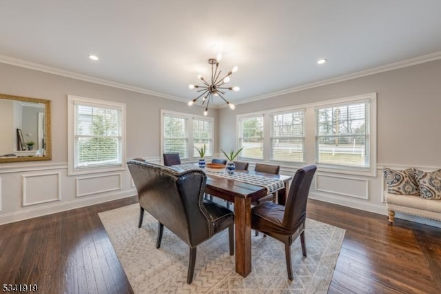 dining space with ornamental molding, hardwood / wood-style floors, wainscoting, and a notable chandelier