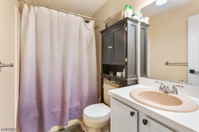 bathroom featuring a shower with shower curtain, toilet, and vanity