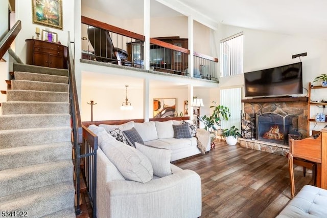 living area with stairway, high vaulted ceiling, wood finished floors, and a fireplace