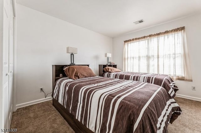 carpeted bedroom featuring baseboards and visible vents