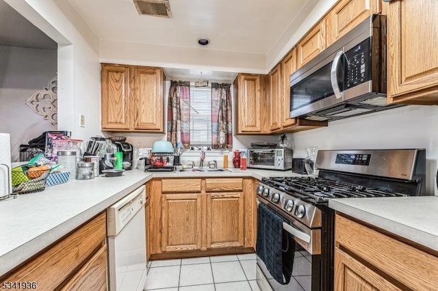 kitchen with a toaster, visible vents, appliances with stainless steel finishes, light countertops, and a sink