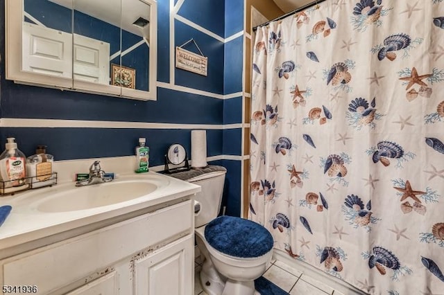 bathroom with curtained shower, vanity, toilet, and tile patterned floors