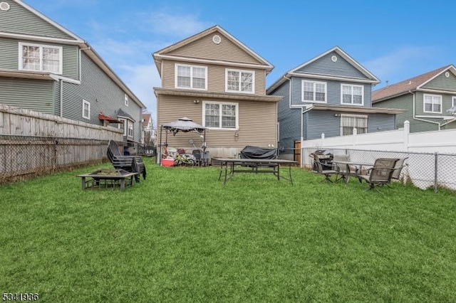 back of property with a fenced backyard and a lawn