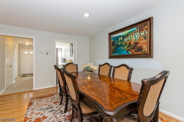 dining area featuring light wood-style flooring and baseboards