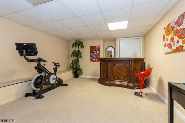 workout area featuring a drop ceiling, carpet, and baseboards