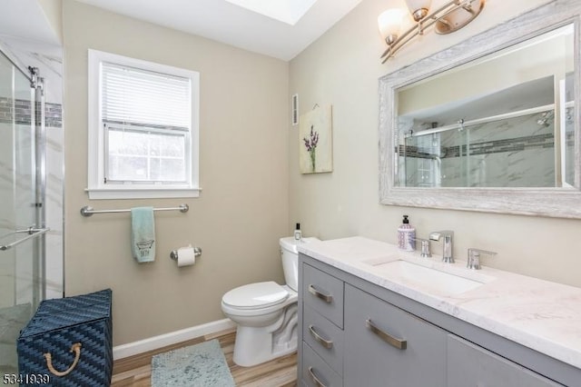 full bath with a skylight, toilet, a stall shower, wood finished floors, and baseboards