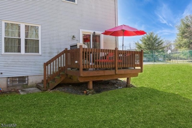 wooden terrace featuring a lawn and fence