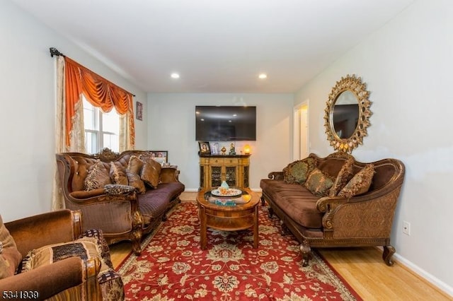 living area featuring baseboards, wood finished floors, and recessed lighting