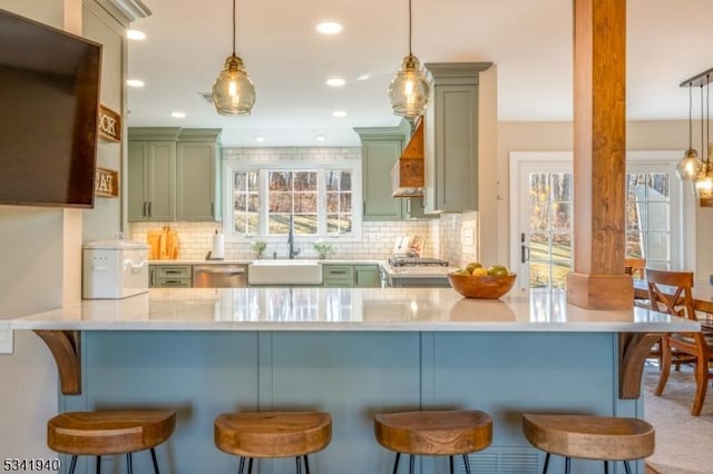 kitchen with decorative backsplash, a sink, and light countertops