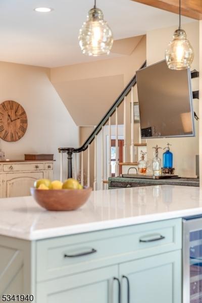 kitchen with light countertops, wine cooler, and decorative light fixtures