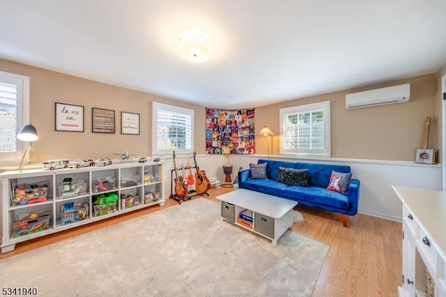 game room with an AC wall unit and wood finished floors