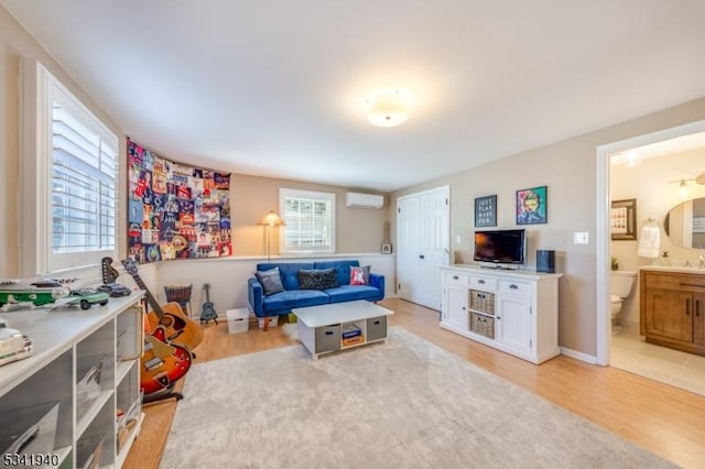 living room featuring an AC wall unit and light wood finished floors