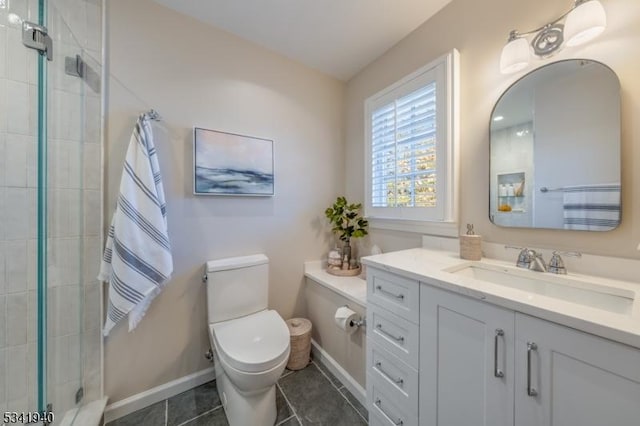 bathroom featuring toilet, vanity, baseboards, tiled shower, and tile patterned floors