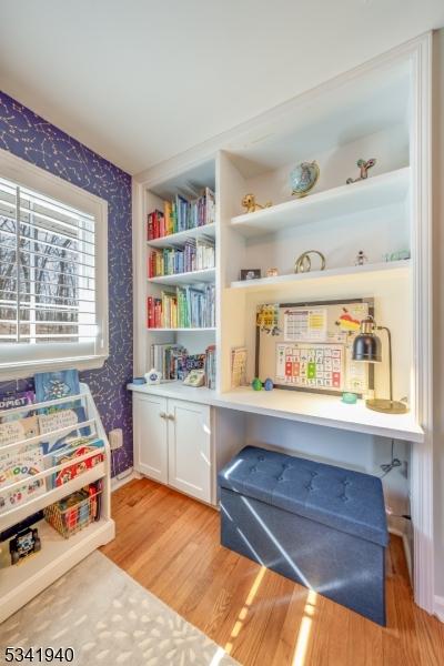 rec room with light wood-type flooring, wallpapered walls, and baseboards