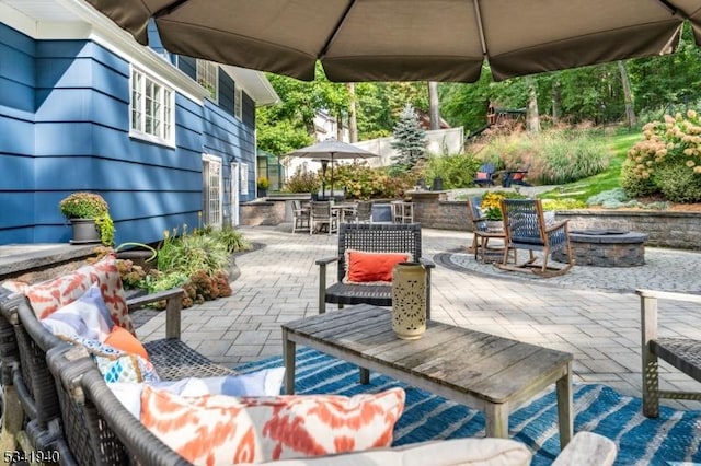 view of patio / terrace with outdoor dining area and an outdoor living space with a fire pit