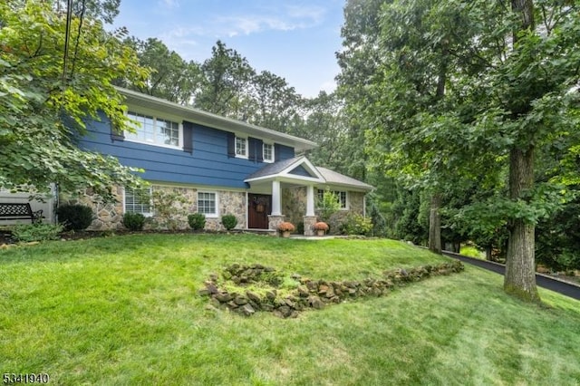 view of front of house with stone siding and a front lawn