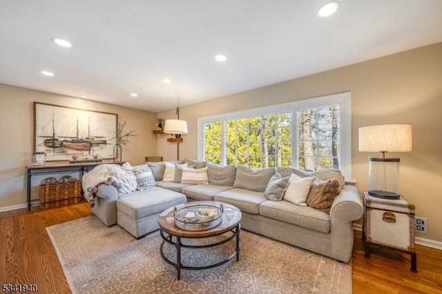 living room with baseboards, wood finished floors, and recessed lighting