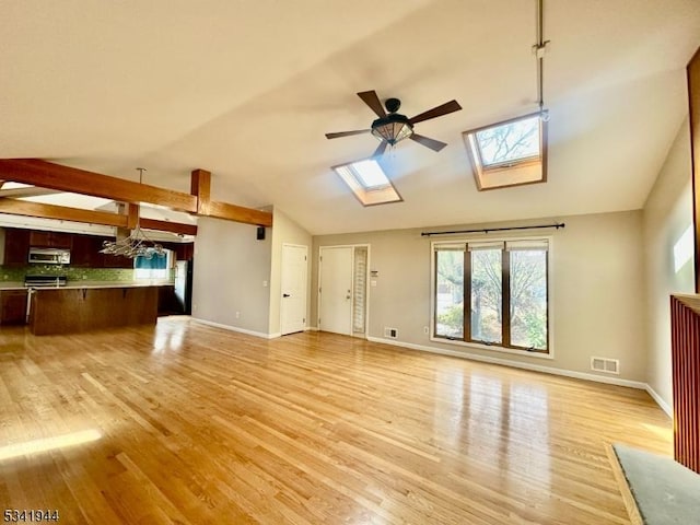 unfurnished living room with light wood-style floors, lofted ceiling with skylight, a ceiling fan, and visible vents