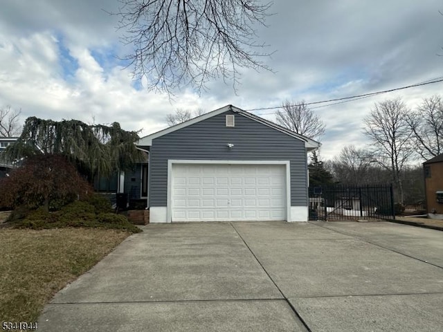 garage with driveway and fence