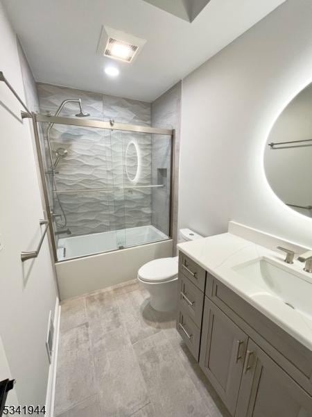 bathroom featuring vanity, toilet, visible vents, and enclosed tub / shower combo