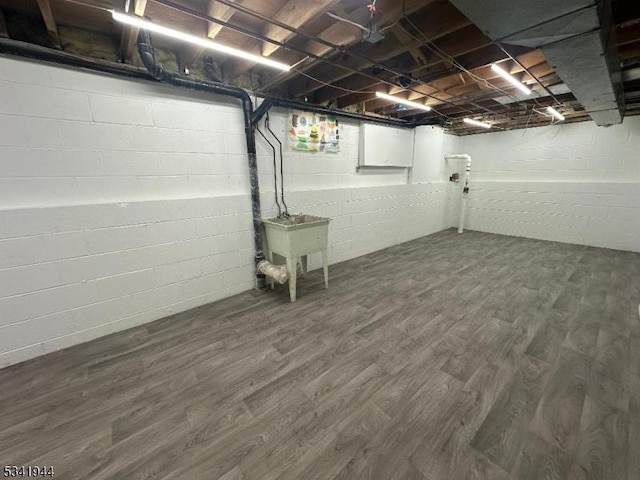 unfinished below grade area with a sink and dark wood-style floors