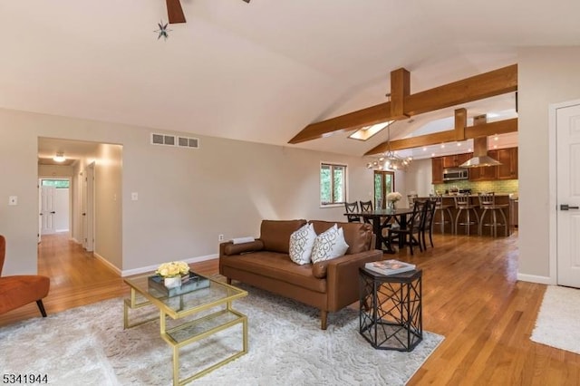 living area with lofted ceiling, light wood-style flooring, visible vents, and ceiling fan