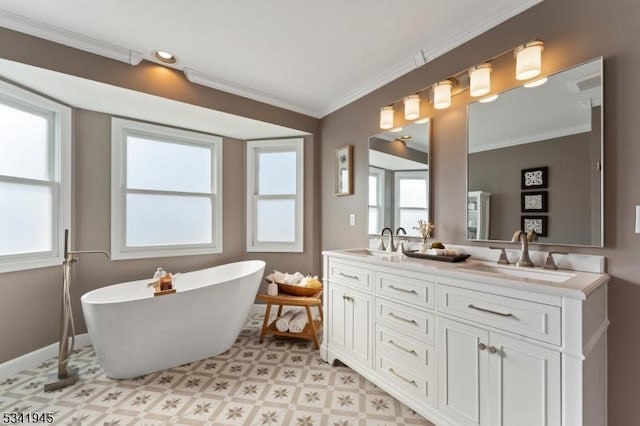 bathroom featuring double vanity, a freestanding bath, crown molding, and a sink