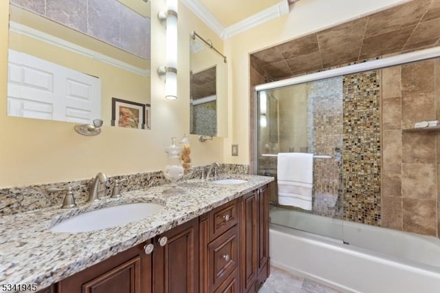 bathroom featuring crown molding, double vanity, combined bath / shower with glass door, and a sink