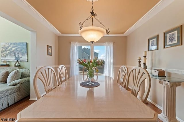 dining room featuring wood finished floors and ornamental molding