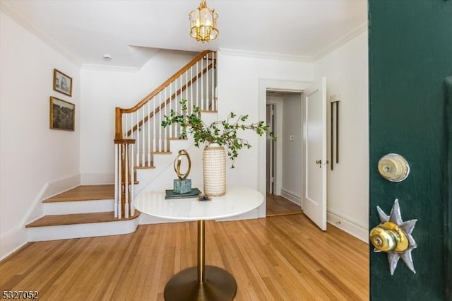 interior space featuring stairs, crown molding, baseboards, and light wood-type flooring