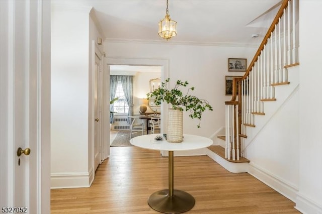 foyer with stairway, light wood-style flooring, baseboards, and ornamental molding