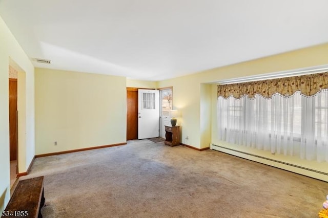 carpeted spare room with a baseboard heating unit, visible vents, and baseboards