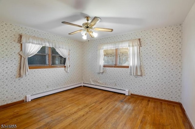 empty room featuring wallpapered walls, wood finished floors, baseboards, and a ceiling fan