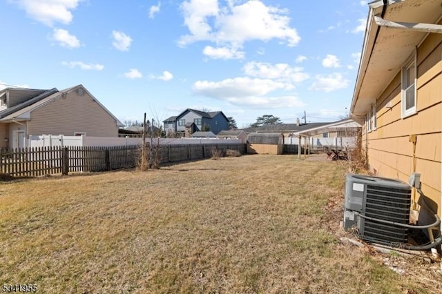 view of yard with central AC and a fenced backyard