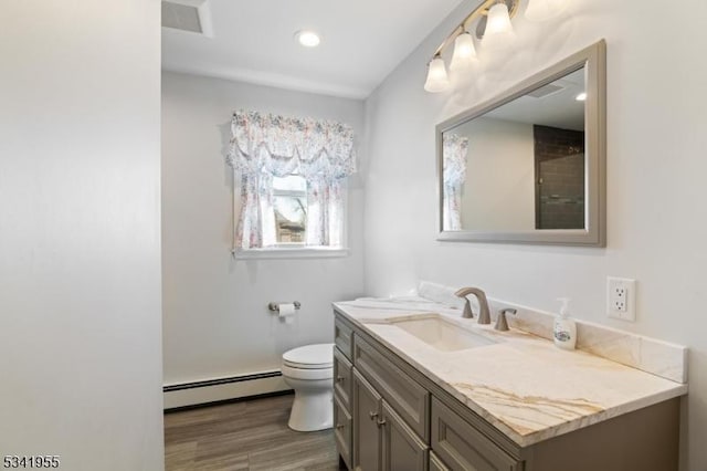 bathroom featuring visible vents, toilet, wood finished floors, vanity, and a baseboard radiator