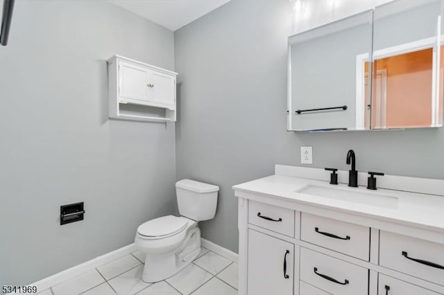 bathroom featuring baseboards, vanity, and toilet