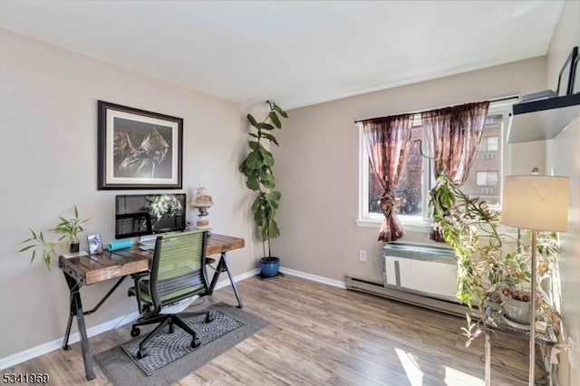 office featuring a baseboard radiator, light wood-style flooring, and baseboards